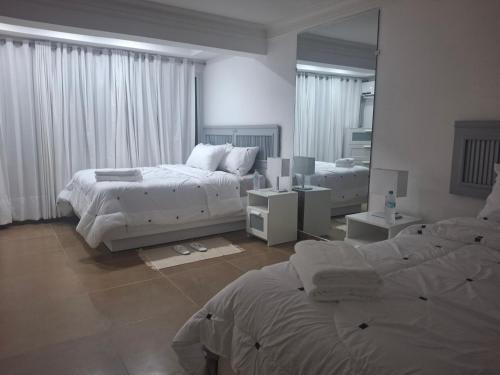 a bedroom with two beds and a large mirror at Spacious Condo with 2 queen beds in Sosua walking distance from everything in Sosúa