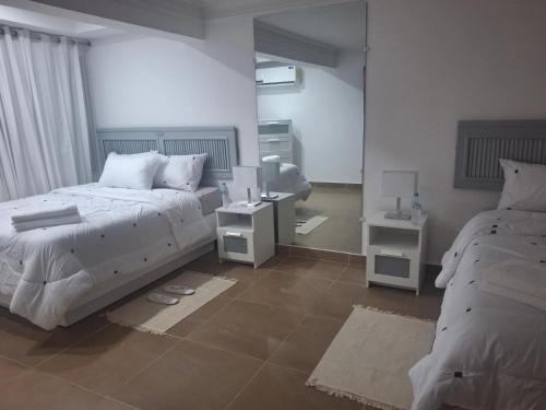 ソスアにあるSpacious Condo with 2 queen beds in Sosua walking distance from everythingのベッドルーム1室(ベッド2台、ナイトスタンド2台付)