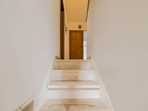 a hallway with white stairs and a wooden door at Quiet valley view retreat in Roy