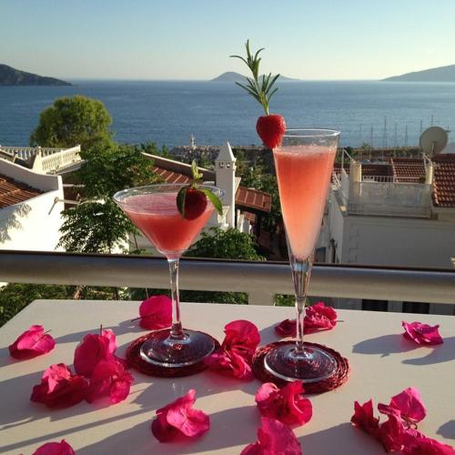 two martini glasses on a table with a view of the ocean at The White House Kalkan in Kalkan