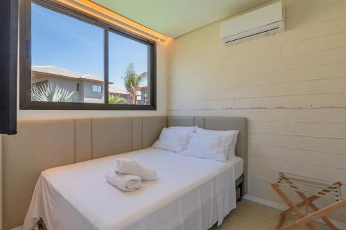 a small bed in a room with a window at JG Flecheiras in Trairi