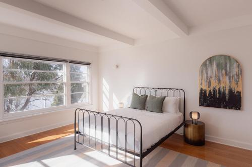 a white bedroom with a bed and a window at Light and Bright Trevallyn Stay with River Views in Royal Park
