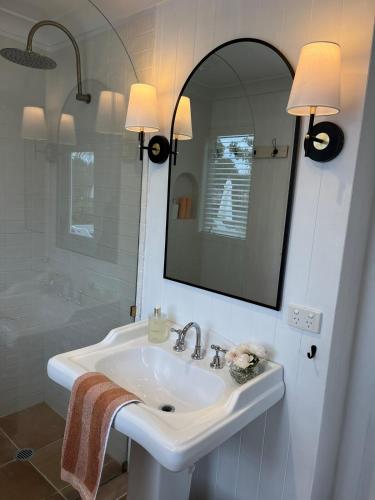 a white bathroom with a sink and a mirror at Gorgeous Country Cottage In Lovely Private Grounds in Scone
