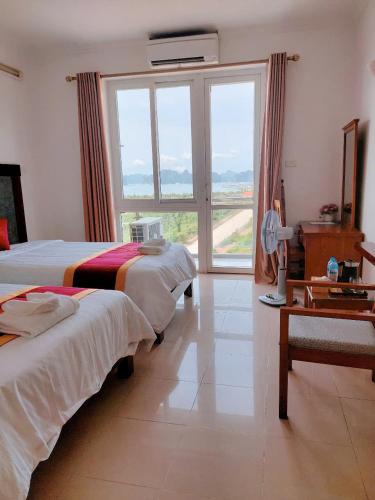 a hotel room with two beds and a large window at Khách sạn HTC REGINA TUẦN CHÂU in Ha Long