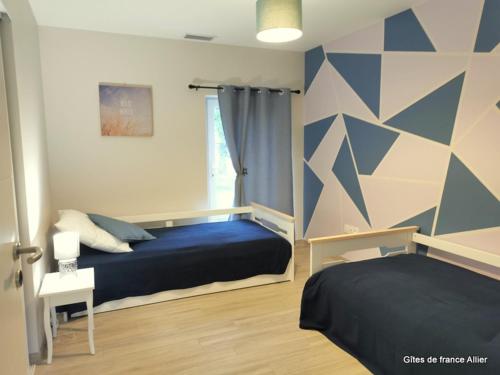 a bedroom with a blue bed and a window at Gîte de Charme avec Terrasse Privative et Grand Jardin près du Parc Le Pal - FR-1-489-339 in Thiel-sur-Acolin