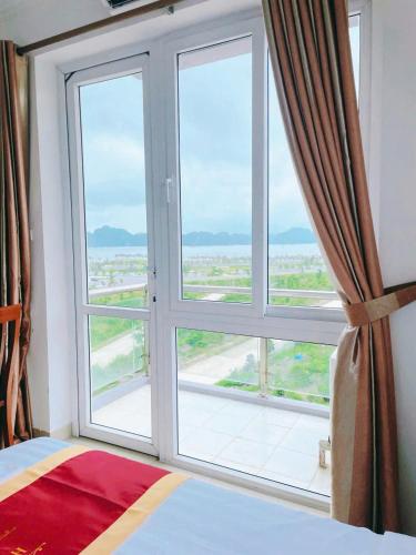 a bedroom with a large window with a view at Khách sạn HTC REGINA TUẦN CHÂU in Ha Long