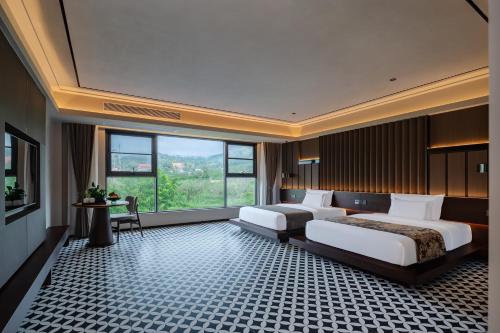 a hotel room with two beds and a large window at 诺亚度假酒店 in Luang Prabang