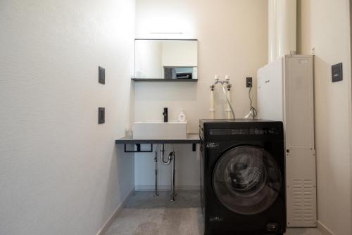 a laundry room with a washing machine and a table at Alpine North Peak in Furano