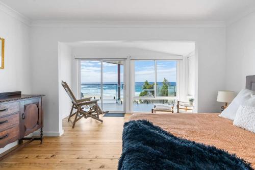 a bedroom with a bed with a view of the ocean at Ocean Overlook - Rennies Beach holiday haven in Ulladulla