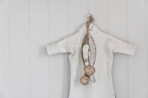 a white shirt hanging on a wall with two tags at Ocean Overlook - Rennies Beach holiday haven in Ulladulla