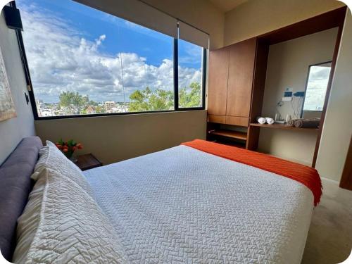 a bedroom with a bed and a large window at Mangle 13 Modern Apartments-Rooftop pool, close to Ferry in Cancún