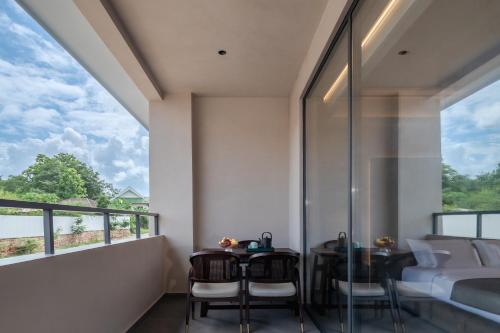 a room with a balcony with a bed and a table and chairs at 诺亚度假酒店 in Luang Prabang