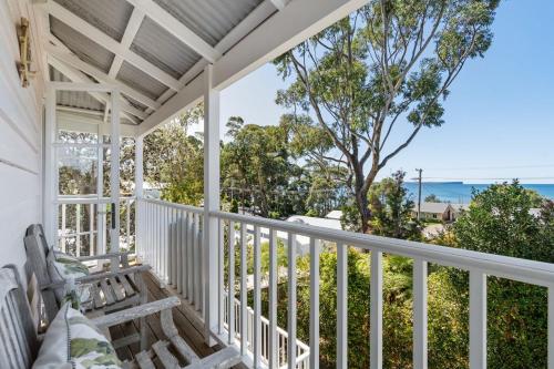 a porch with a bench and a view of the ocean at Whalers Retreat - Hyams Beach 3BR cottage in Hyams Beach