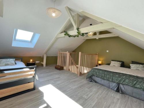 a attic bedroom with two beds and a staircase at Gîte spacieux dans le Perche avec WIFI inclus, idéal pour réunions familiales - FR-1-497-240 in Val-au-Perche