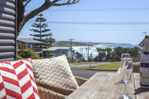 a wooden table with an american flag pillows on a patio at Stunning Views - beach cottage with ocean vistas in Burrill Lake