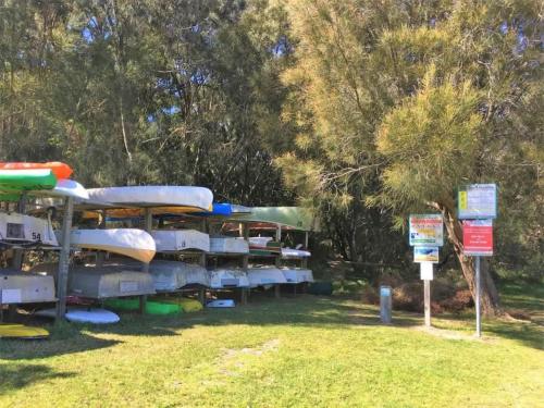 a bunch of boats parked in a park with signs at Stunning Views - beach cottage with ocean vistas in Burrill Lake