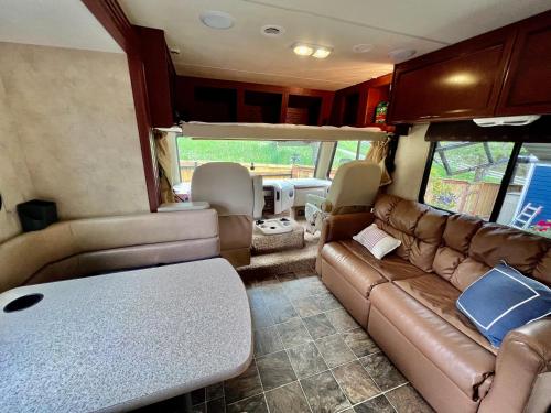 a living room of an rv with a couch and chairs at Quiet Peaceful Backyard Class-A RV Near Airport in Seattle