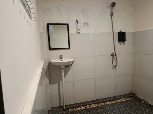 a bathroom with a sink and a mirror on the wall at The Daun Puntik HomeStay in Pawenang