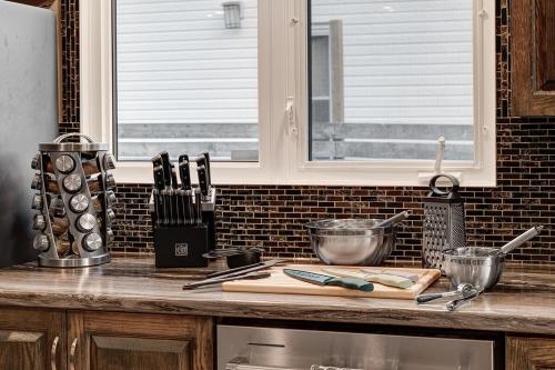 a kitchen counter with a cutting board and some knives at 3 Bedroom Modern Getaway with Hot Tub and Pet Friendly in Sudbury