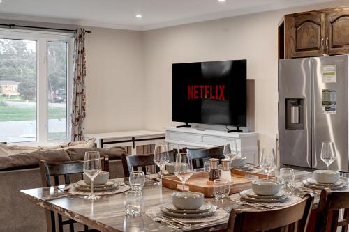 a dining room with a table and a television at 3 Bedroom Modern Getaway with Hot Tub and Pet Friendly in Sudbury