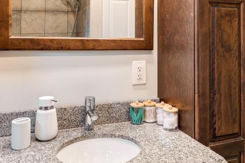 a bathroom counter with a sink and a mirror at 3 Bedroom Modern Getaway with Hot Tub and Pet Friendly in Sudbury