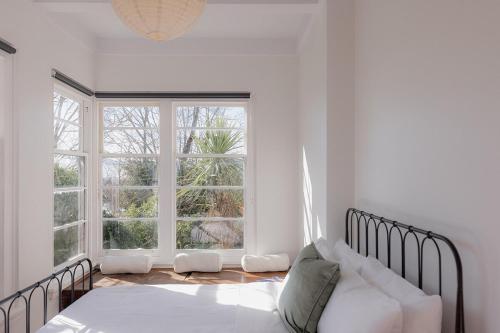 une chambre avec un lit et une grande fenêtre dans l'établissement Tamar River Views Mid-Century Vibes, à Royal Park