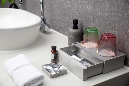 a bathroom with a sink with two glass containers on it at 上海浦东机场华美达安可酒店-免费提供24小时浦东机场班车十分钟到达候机楼出发层 in Shanghai