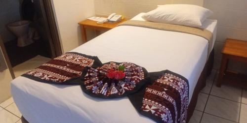 a bed with two pillows on it with a phone at Grand Melanesian Hotel in Nadi