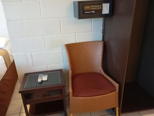 a room with a chair and a table with a nightstand at Grand Melanesian Hotel in Nadi