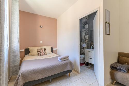 a small bedroom with a bed and a bathroom at Le cocon de l'impasse à Tremblay en France in Tremblay En France
