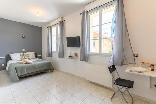 a bedroom with a bed and a window and a chair at Le cocon de l'impasse à Tremblay en France in Tremblay En France
