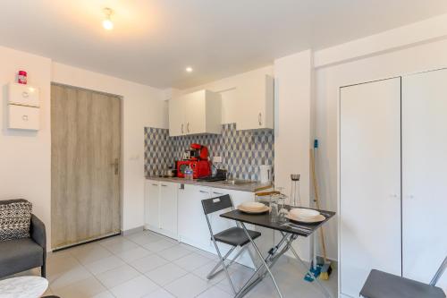 a small kitchen with a table and a chair at Le cocon de l'impasse à Tremblay en France in Tremblay En France