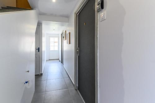 a hallway with white walls and a tile floor at Le cocon de l'impasse à Tremblay en France in Tremblay En France
