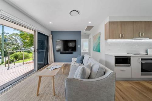 a living room with a couch and a table at Elements of Hyams - perfect Hyams Beach getaway in Hyams Beach