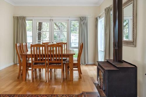 a dining room with a table and a wood stove at Bowen View - pet-friendly home near Hyams Beach in Hyams Beach