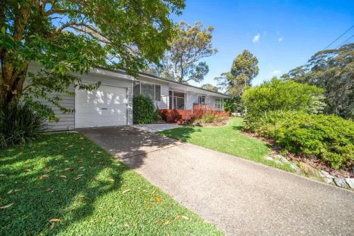 a house with a garage and a driveway at Elements of Hyams - perfect Hyams Beach getaway in Hyams Beach