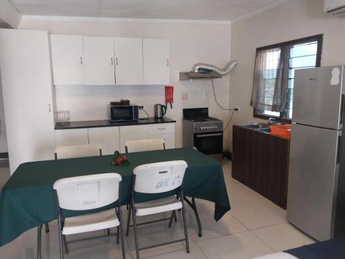 a kitchen with a table and chairs and a refrigerator at Grand Melanesian Hotel in Nadi