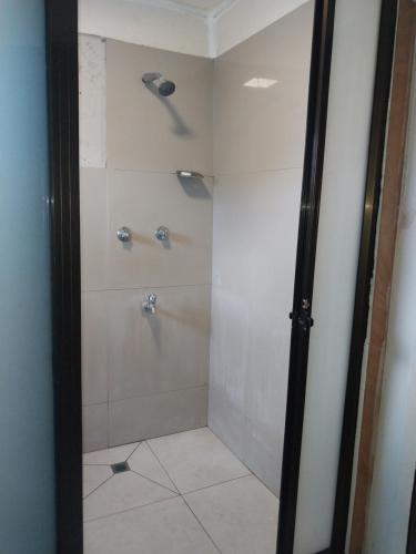 a bathroom with a shower with a glass door at Grand Melanesian Hotel in Nadi