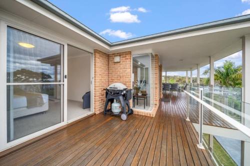 a home with a porch with a stroller on the deck at Footprints at Hyams Beach - 4BR home w. games room in Hyams Beach