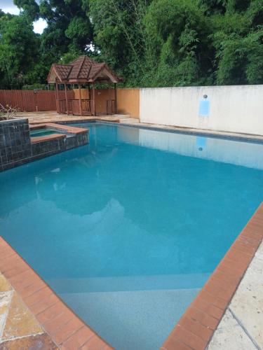 a large blue swimming pool with a gazebo at Embassy Royale in Kingston
