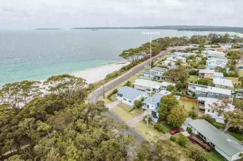 Una vista aérea de una playa con casas y el océano. en Seahaven - pet-friendly retreat near Hyams Beach, en Hyams Beach