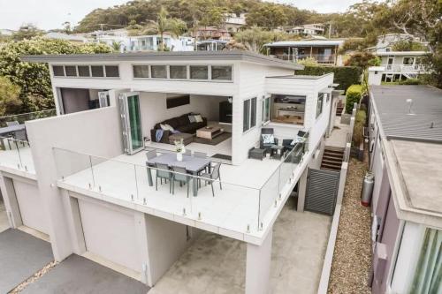 an aerial view of a white house with a table and chairs at Allure at Hyams Beach - seconds to white sands in Hyams Beach