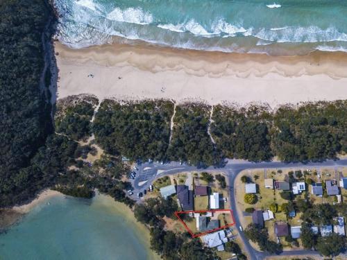 een bovenaanzicht van een strand en de oceaan bij Pelican Beach House - 50m from inlet & playground in Narrawallee