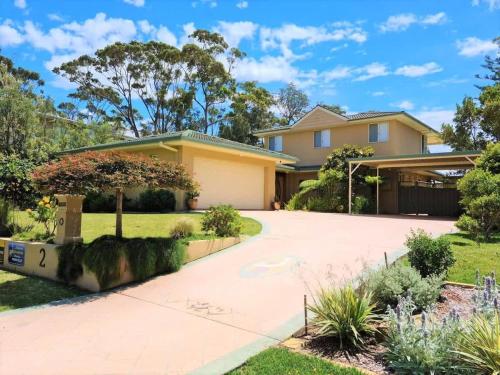 een huis met een oprit ervoor bij Pelican Beach House - 50m from inlet & playground in Narrawallee