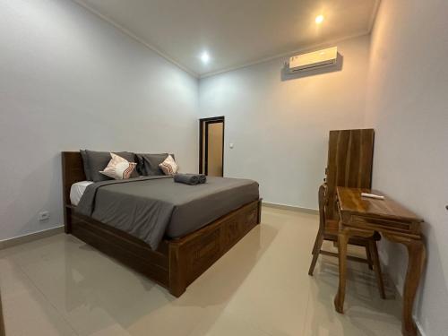 a bedroom with a bed and a table and a desk at Pristine penida in Nusa Penida