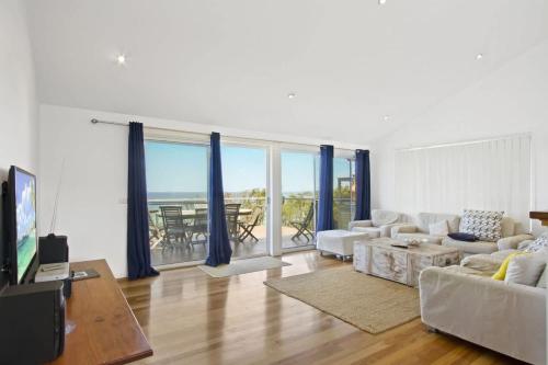 a living room with a couch and a table at Sticks by the Sea - pet-friendly coastal home in Manyana