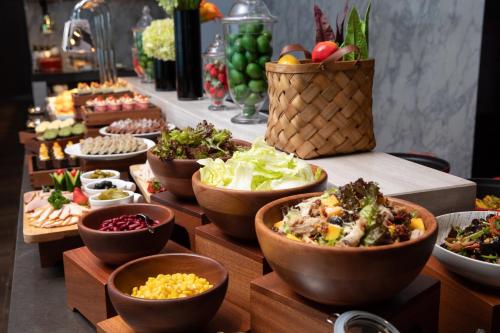 a buffet with bowls of different types of food at Hampton by Hilton Guangzhou Xintang-Free Canton Fair Shuttle in Zengcheng