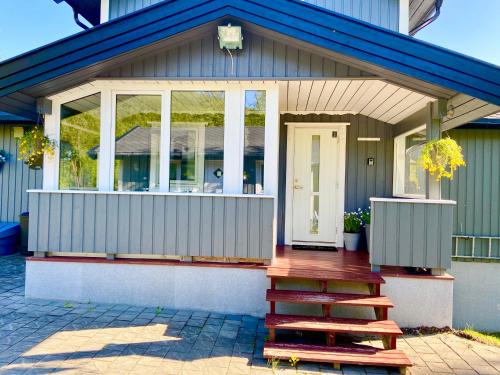 a small house with a staircase in front of it at Riverfront house with 98 inch TV, ps5 & activities in Narvik
