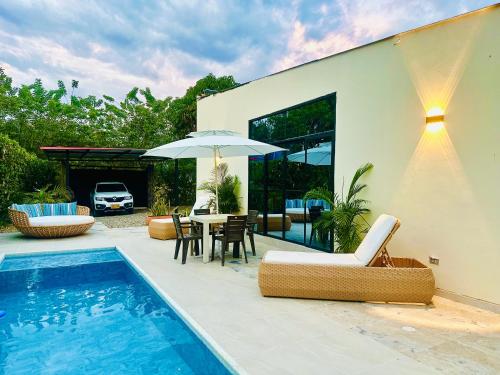 a house with a swimming pool and a table and chairs at Villa Paz CASA QUINTA CON PISCINA PRIVADA in Ricaurte
