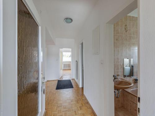 a hallway of a bathroom with a sink and a tub at Nature Escape in Fuldabruck in Fuldabrück